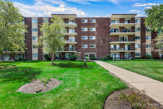 Front view of a multi-story apartment building with balconies.