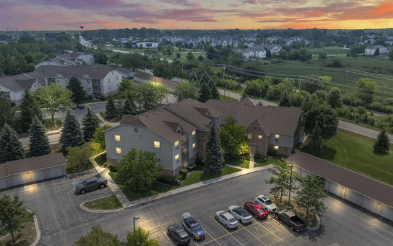 Aerial view of residential buildings and parking area at sunset.