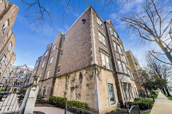 Front view of a multi-story brick building with architectural detailing.