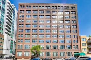 Front view of a multi-story brick building with numerous windows.