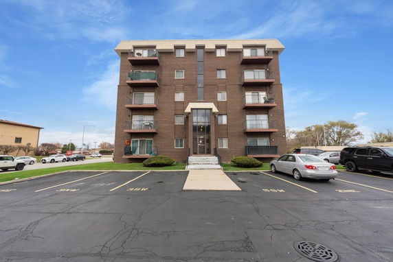 Front view of a five-story apartment building with balconies on each floor.