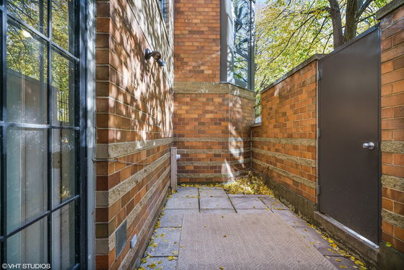 Corner view of a brick building with a pathway and door.