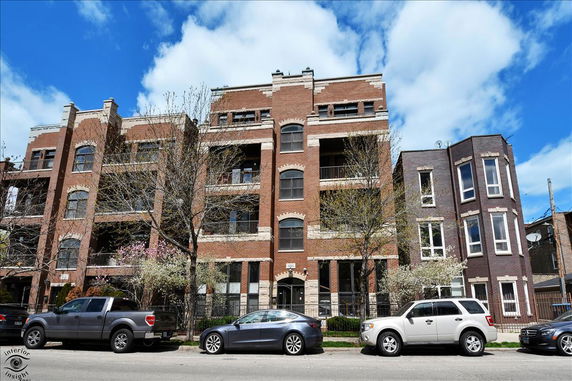 Front view of a multi-story brick building with balconies.