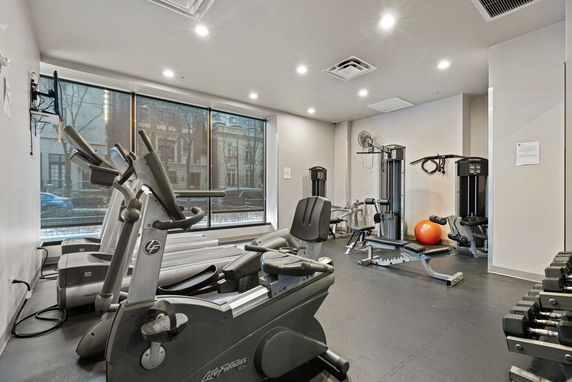 Indoor gym area with exercise machines and equipment.