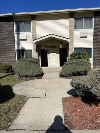 Front view of a two-story building with brick and siding exterior.