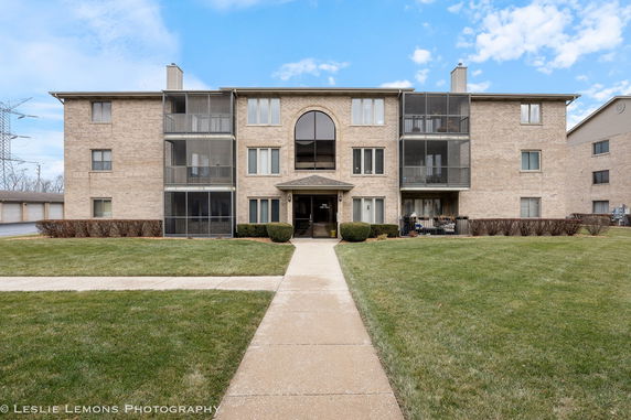 Front view of a multi-story apartment building with screened balconies.