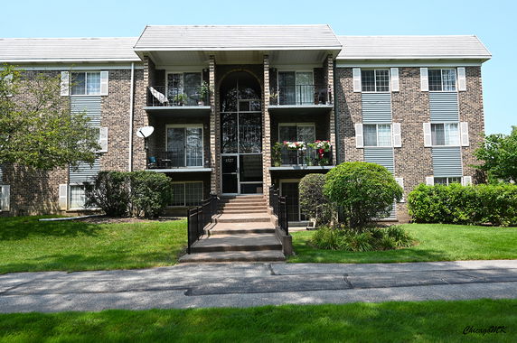 Front view of a multi-story apartment building with balconies.
