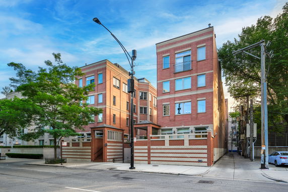 Front view of a multi-story residential building with brick facade.