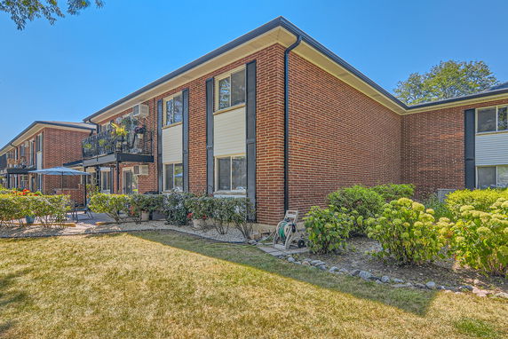 Front view of a two-story brick apartment building with balconies.