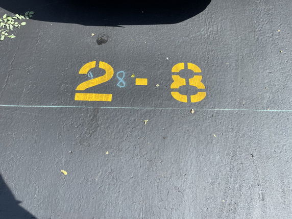 Numbered parking space with 28 painted on the ground.