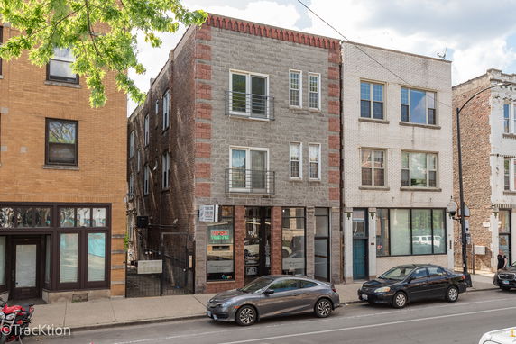Front view of a three-story commercial building with mixed brick facade.