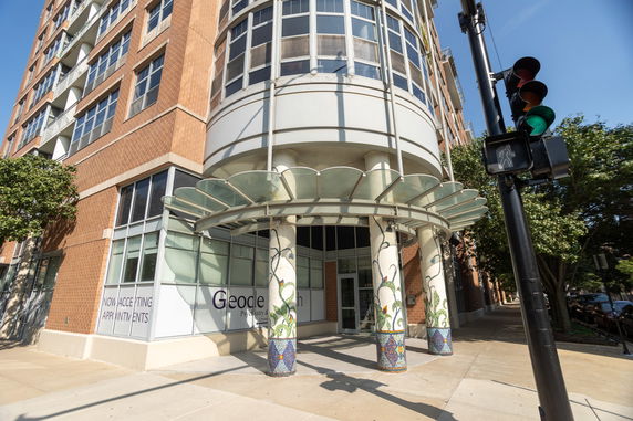 Front view of a modern multi-story building with decorative columns and large windows.