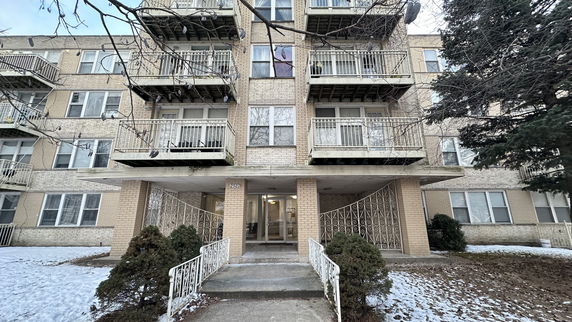 Front view of a multi-story apartment building with balconies.