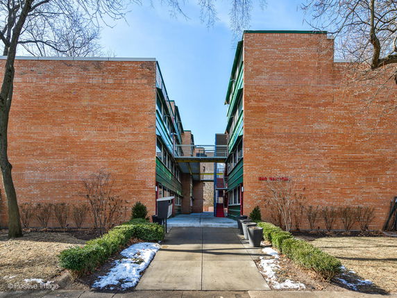 Front view of a modern brick apartment building with a central walkway.