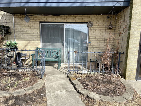 Front view of a house with a patio and sliding glass door.