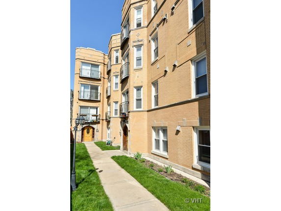 Front view of a multi-story brick building with multiple entrances.