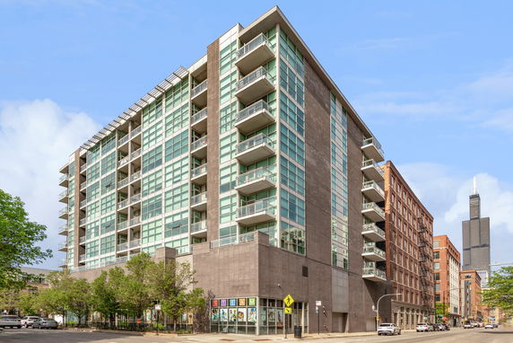 Front view of a multi-story modern building with glass balconies.