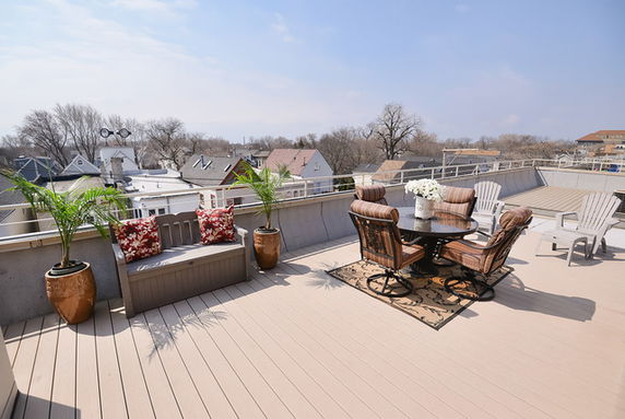 Rooftop patio with outdoor seating and potted plants.