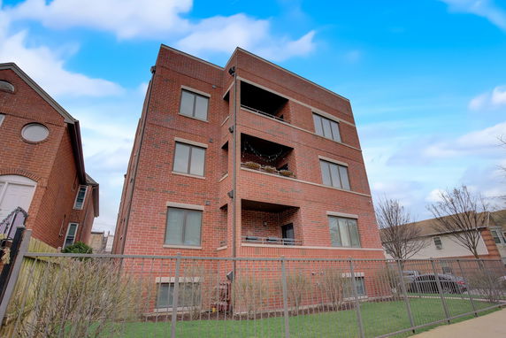 Front view of a multi-story brick building with balconies.