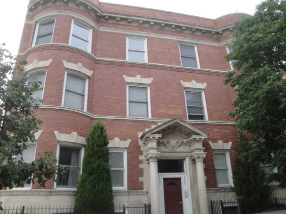 Front view of a three-story brick building with decorative entrance.