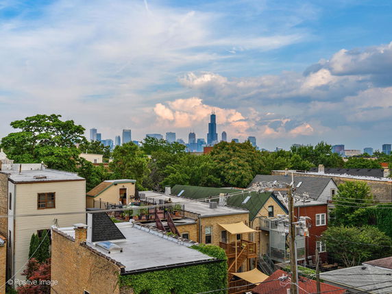 Panoramic view of residential rooftops with a city skyline in the background.
