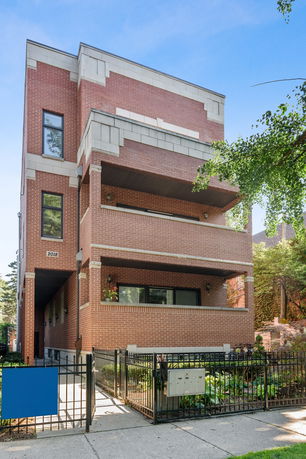 Front view of a brick multi-story building with balconies.