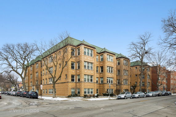 Front view of a multi-story brick apartment building on a corner.