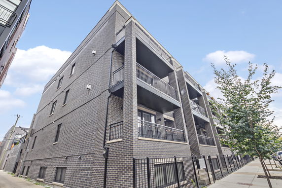 Angled view of a multi-story brick building with balconies.