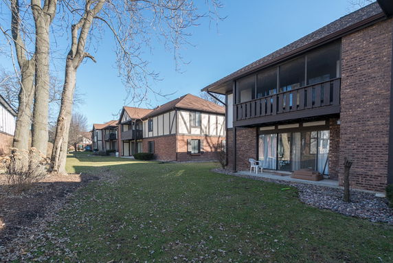 Front view of a row of two-story brick buildings with balconies.
