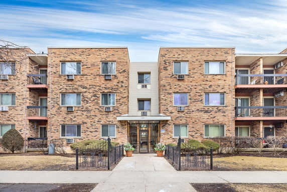 Front view of a multi-story apartment building with balconies.