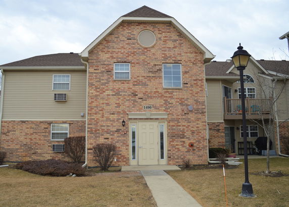 Front view of a multi-story brick house with a beige door.