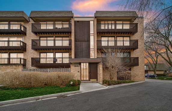 Front view of a multi-story apartment building with balconies.