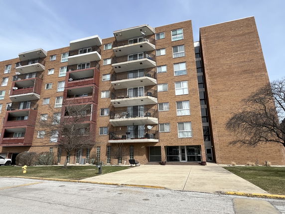 Front view of a multi-story apartment building with balconies.