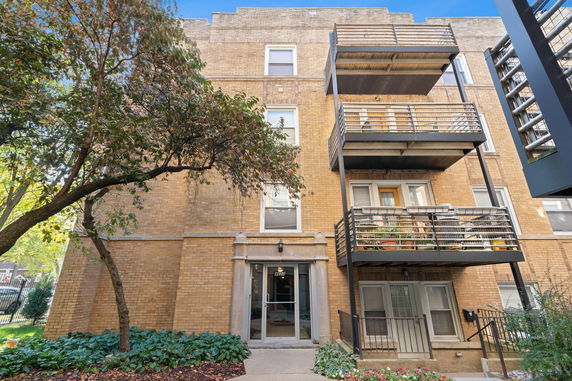 Front view of a multi-story brick building with balconies.