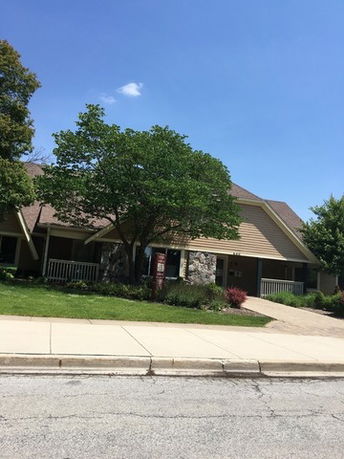 Front view of a house with a sloped roof and stone details.