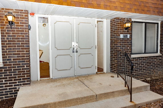 Front entrance of a building with double doors and brick exterior.