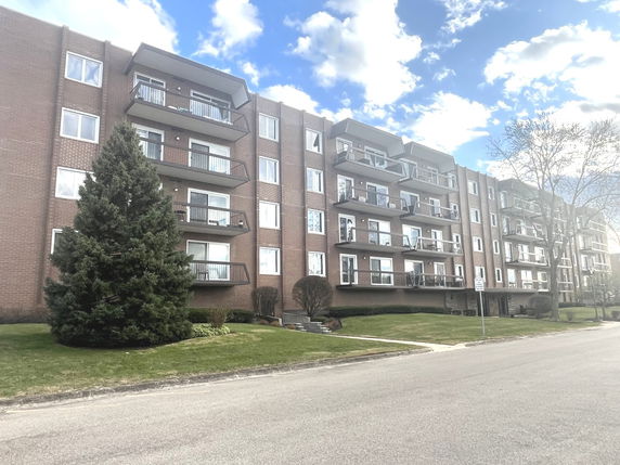 Front view of a multi-story apartment building with balconies.