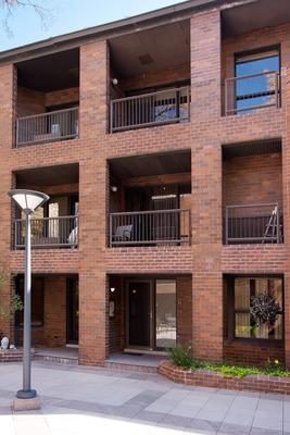 Front view of a multi-story brick building with balconies.