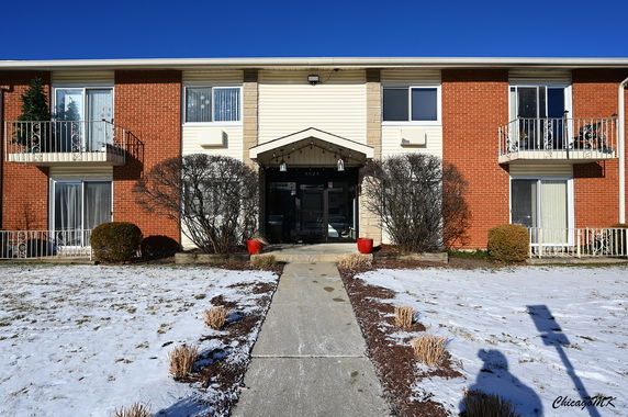Front view of a two-story building with balconies and a central entrance.