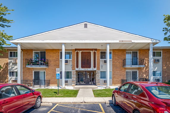 Front view of a two-story apartment building with brick exterior and columns.