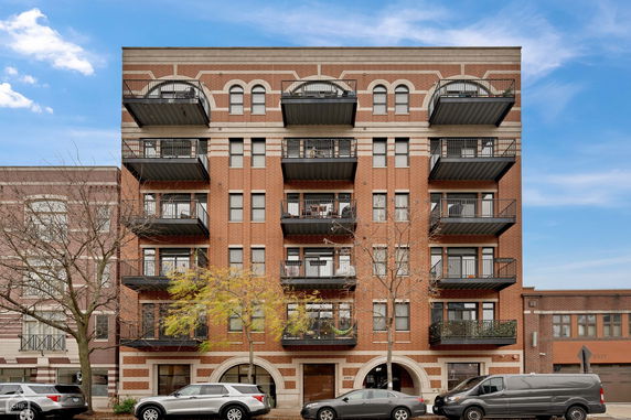 Front view of a multi-story brick building with balconies.