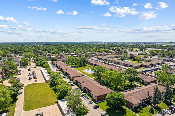 Aerial panoramic view of a residential area with multiple buildings and greenery.