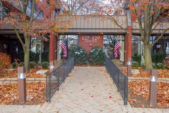 Front view of a brick building entrance with American flags.