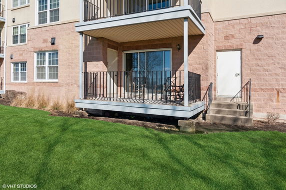 Front view of a building with balconies and a sliding glass door.