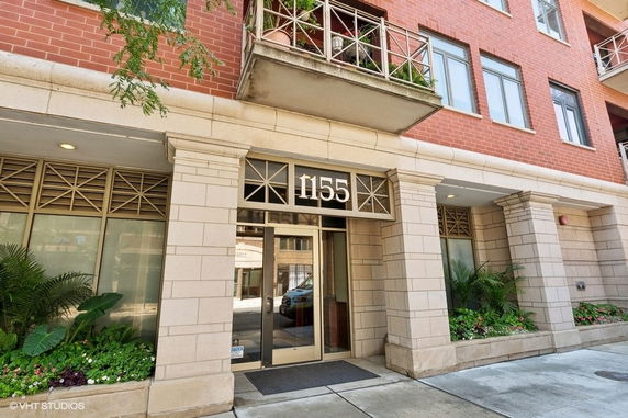 Front view of a building with a glass entrance and red brick exterior.