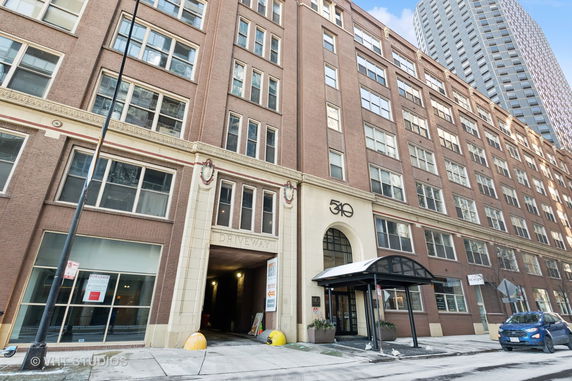 Front view of a multi-story brick building with multiple windows and an entrance labeled 'Driveway'.