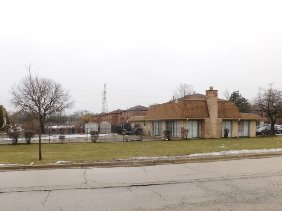 Front view of a single-story house with a sloped roof and chimney.
