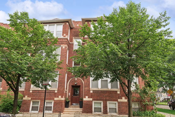 Front view of a multi-story brick building with windows and a central entrance.