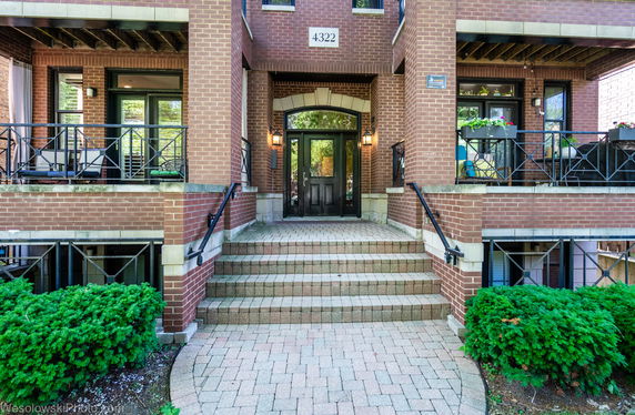 Front view of a brick building with steps leading to the entrance.