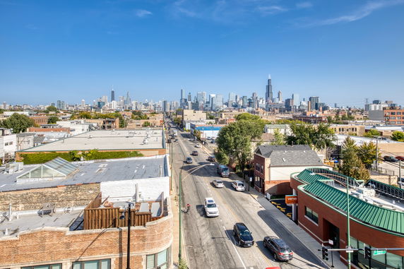 Panoramic view of a cityscape with roads and buildings.
